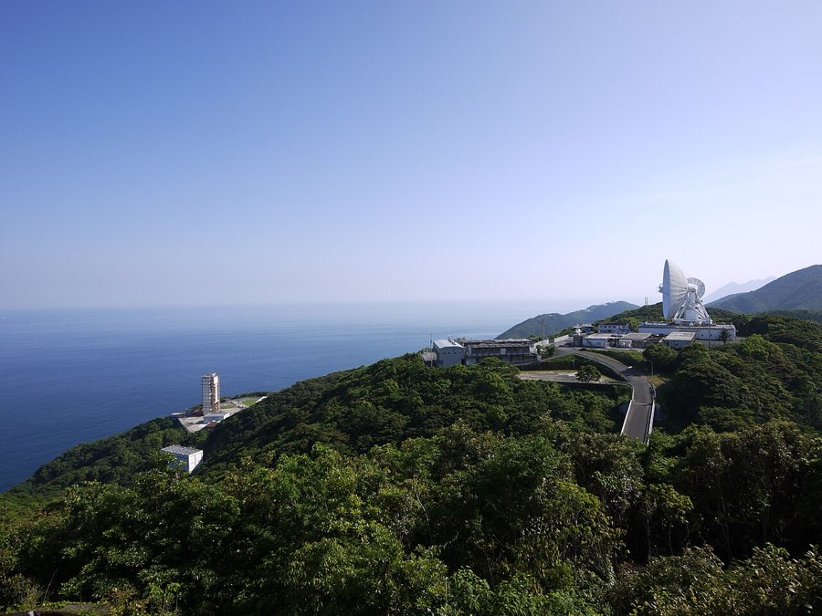 海に面した丘の上に建つ内之浦宇宙空間観測所。右手に大型パラボラアンテナ、左手前に発射装置が見える